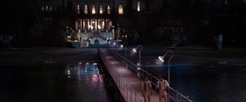 Movie still from “The Great Gatsby” (2013), directed by Baz Luhrmann – A couple of men walking across a bridge at night; Extreme Wide shot, High angle