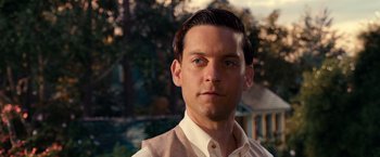 Movie still from “The Great Gatsby” (2013), directed by Baz Luhrmann – A person wearing a shirt and vest; Close Up shot, Over the shoulder angle