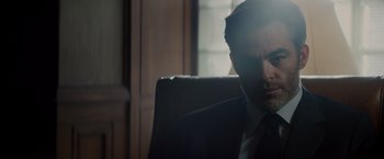 Movie still from “All the Old Knives” (2022), directed by Janus Metz – A person wearing a suit and tie; Close Up shot, Low angle
