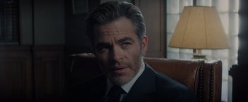 Movie still from “All the Old Knives” (2022), directed by Janus Metz – A person wearing a suit and tie; Close Up shot, Over the shoulder angle