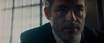 Movie still from “All the Old Knives” (2022), directed by Janus Metz – A person wearing a suit and tie; Close Up shot, Low angle