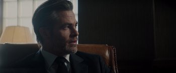 Movie still from “All the Old Knives” (2022), directed by Janus Metz – A person wearing a suit and tie; Close Up shot, Over the shoulder angle