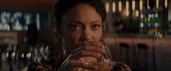 Movie still from “All the Old Knives” (2022), directed by Janus Metz – A person holding a glass of wine; Close Up shot, Over the shoulder angle