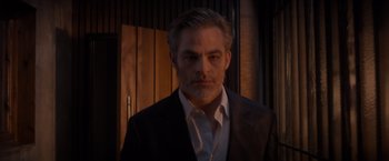 Movie still from “All the Old Knives” (2022), directed by Janus Metz – A person wearing a suit and tie; Medium shot, Low angle