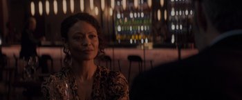 Movie still from “All the Old Knives” (2022), directed by Janus Metz – A woman is sitting in front of a bunch of lights; Close Up shot, Over the shoulder angle