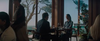 Movie still from “All the Old Knives” (2022), directed by Janus Metz – Two men are sitting at a table with wine glasses; Medium shot, Over the shoulder angle