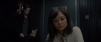 Movie still from “All the Old Knives” (2022), directed by Janus Metz – A woman sitting in front of a door looking sad; Close Up shot, Over the shoulder angle