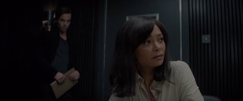 Movie still from “All the Old Knives” (2022), directed by Janus Metz – A woman in a white shirt is standing in a room; Close Up shot, Over the shoulder angle