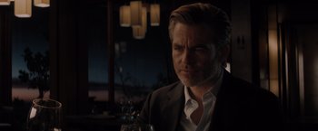 Movie still from “All the Old Knives” (2022), directed by Janus Metz – A person sitting at a table with a glass of wine; Close Up shot, Over the shoulder angle