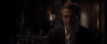 Movie still from “All the Old Knives” (2022), directed by Janus Metz – A person wearing a suit and tie; Close Up shot, Over the shoulder angle