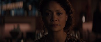 Movie still from “All the Old Knives” (2022), directed by Janus Metz – A person with curly hair looking at the camera; Close Up shot, Over the shoulder angle