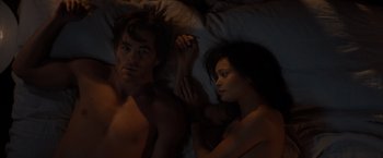 Movie still from “All the Old Knives” (2022), directed by Janus Metz – A man and a woman laying in a bed; Medium shot, Overhead angle