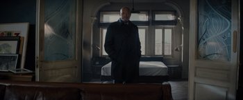 Movie still from “All the Old Knives” (2022), directed by Janus Metz – A man standing in front of a mirror in a room; Wide shot, Low angle