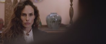 Movie still from “All the Places” (2023), directed by Pitipol Ybarra – A woman sitting in front of a vase on a table; Close Up shot, Over the shoulder angle