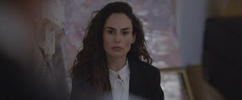 Movie still from “All the Places” (2023), directed by Pitipol Ybarra – A woman in a black jacket and a white shirt; Close Up shot, Over the shoulder angle