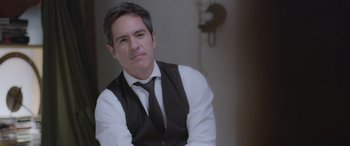 Movie still from “All the Places” (2023), directed by Pitipol Ybarra – A man wearing a vest and a black tie; Close Up shot, Over the shoulder angle