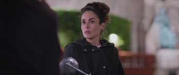 Movie still from “All the Places” (2023), directed by Pitipol Ybarra – A woman in a black jacket holding a sword; Close Up shot, Over the shoulder angle