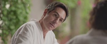 Movie still from “All the Places” (2023), directed by Pitipol Ybarra – A person wearing a white robe; Close Up shot, Over the shoulder angle