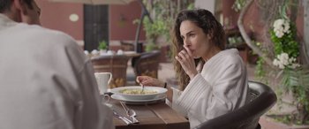 Movie still from “All the Places” (2023), directed by Pitipol Ybarra – A woman sitting in front of a bowl of food; Close Up shot, Over the shoulder angle
