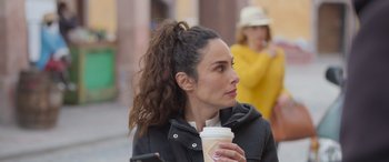 Movie still from “All the Places” (2023), directed by Pitipol Ybarra – A person holding a cup of coffee; Close Up shot, Over the shoulder angle