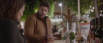 Movie still from “All the Places” (2023), directed by Pitipol Ybarra – A man is holding a wallet in his hand; Medium shot, Over the shoulder angle