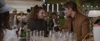 Movie still from “All the Places” (2023), directed by Pitipol Ybarra – A woman and a man are talking to each other at an event; Medium shot, Over the shoulder angle