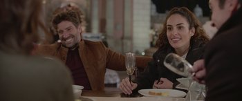 Movie still from “All the Places” (2023), directed by Pitipol Ybarra – A man and a woman sitting at a table with a glass of wine; Medium shot, Over the shoulder angle