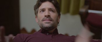 Movie still from “All the Places” (2023), directed by Pitipol Ybarra – A person wearing a maroon shirt; Close Up shot, High angle