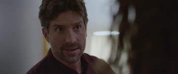 Movie still from “All the Places” (2023), directed by Pitipol Ybarra – A person wearing a shirt; Close Up shot, Over the shoulder angle