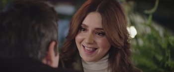 Movie still from “All the Places” (2023), directed by Pitipol Ybarra – A person smiling at the camera; Close Up shot, Over the shoulder angle