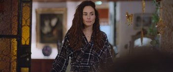 Movie still from “All the Places” (2023), directed by Pitipol Ybarra – A woman with long hair wearing a plaid robe; Medium shot, Over the shoulder angle