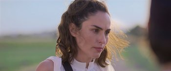 Movie still from “All the Places” (2023), directed by Pitipol Ybarra – A person wearing a white shirt; Close Up shot, Over the shoulder angle