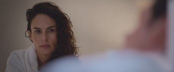 Movie still from “All the Places” (2023), directed by Pitipol Ybarra – A person with curly hair; Close Up shot, Over the shoulder angle