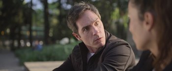 Movie still from “All the Places” (2023), directed by Pitipol Ybarra – A person wearing a jacket; Close Up shot, Over the shoulder angle