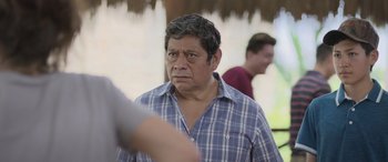 Movie still from “All the Places” (2023), directed by Pitipol Ybarra – A man in a plaid shirt is looking at the camera; Close Up shot, Over the shoulder angle