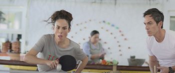 Movie still from “All the Places” (2023), directed by Pitipol Ybarra – A woman is playing ping pong while another woman watches; Close Up shot, Over the shoulder angle
