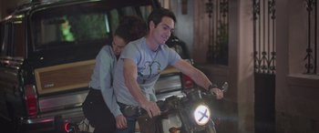 Movie still from “All the Places” (2023), directed by Pitipol Ybarra – A man and a woman riding a motorcycle; Medium shot, High angle