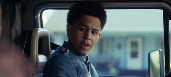 Movie still from “All Together Now” (2020), directed by Brett Haley – A young man sitting in the back seat of a car; Close Up shot, Over the shoulder angle