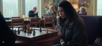 Movie still from “All Together Now” (2020), directed by Brett Haley – A woman sitting in front of a chess board; Close Up shot, Over the shoulder angle