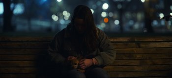 Movie still from “All Together Now” (2020), directed by Brett Haley – A woman sitting on a bench holding a dog; Close Up shot, High angle
