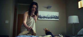 Movie still from “All Together Now” (2020), directed by Brett Haley – A woman in a bath robe and a dog in a room; Medium shot, Over the shoulder angle