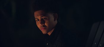 Movie still from “All Together Now” (2020), directed by Brett Haley – A young man in a black shirt is in the dark; Close Up shot, Low angle