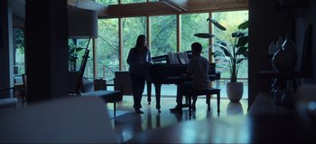 Movie still from “All Together Now” (2020), directed by Brett Haley – Two people standing in front of a piano in a living room; Wide shot, Over the shoulder angle