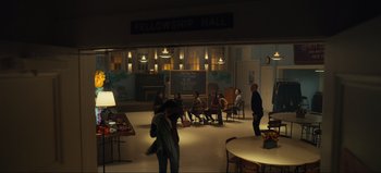 Movie still from “All Together Now” (2020), directed by Brett Haley – A group of people sitting in a room at night; Extreme Wide shot, High angle