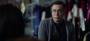 Movie still from “All Together Now” (2020), directed by Brett Haley – A person wearing glasses and a sweater; Close Up shot, Over the shoulder angle