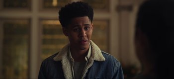 Movie still from “All Together Now” (2020), directed by Brett Haley – A young man in a denim jacket looking at the camera; Close Up shot, Over the shoulder angle