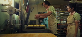 Movie still from “All Together Now” (2020), directed by Brett Haley – A man in an apron is cooking food on a grill; Medium shot, Low angle