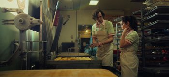 Movie still from “All Together Now” (2020), directed by Brett Haley – A man in a kitchen cooking food on a grill; Medium shot, Low angle