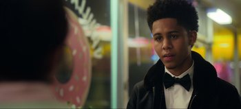 Movie still from “All Together Now” (2020), directed by Brett Haley – A young man in a black jacket and white shirt; Close Up shot, Over the shoulder angle
