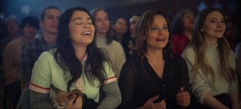 Movie still from “All Together Now” (2020), directed by Brett Haley – Two women are laughing while watching a movie together; Close Up shot, Over the shoulder angle